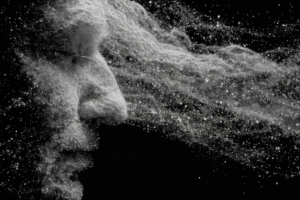 An abstract black and white profile of a human face formed from swirling light and particles against a dark background.